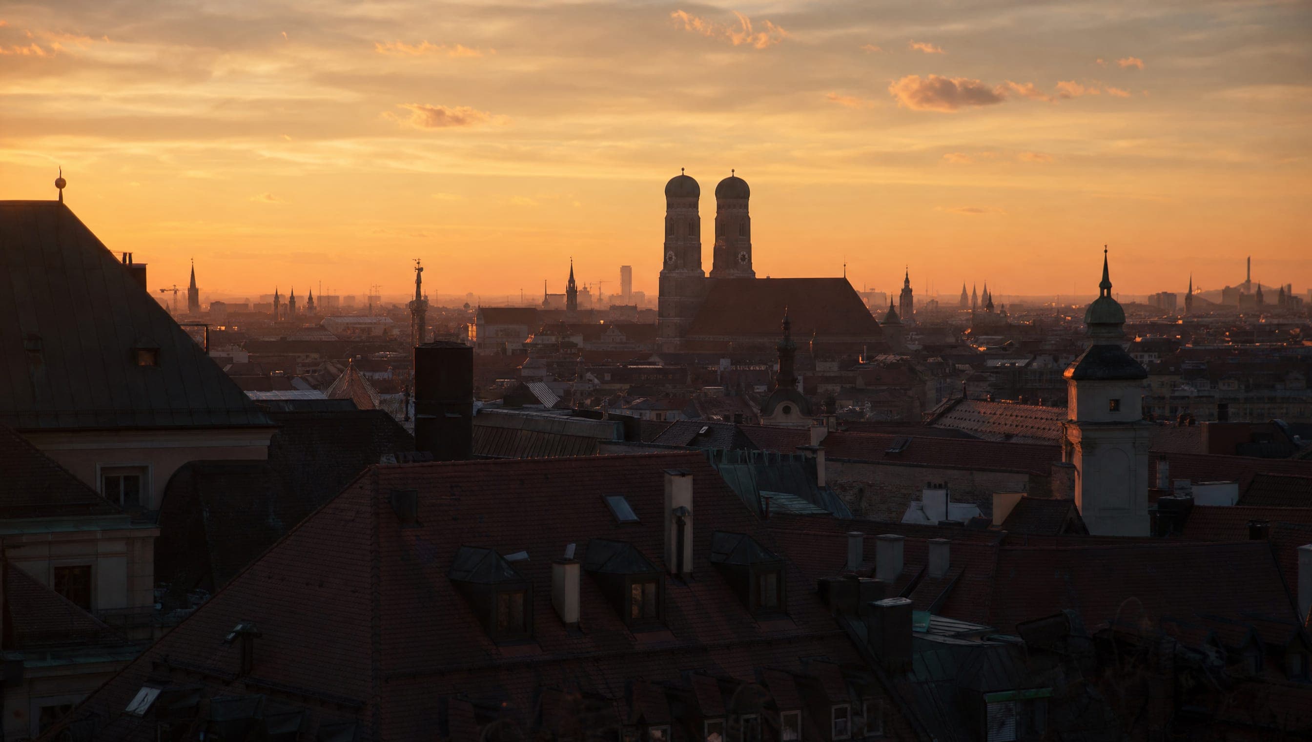 München in der Dämmerung: die Türme der Frauenkirche über den Dächern der Altstadt